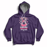 Women’s purple hoodie with front kangaroo pocket, drawstring hood, and pink Women’s Day graphic