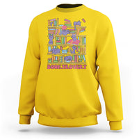 Daisy yellow crewneck sweatshirt with colorful cat-and-bookshelf graphic and text