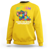 Yellow crewneck sweatshirt with colorful autism graphic and 'Seeing the world differently' print