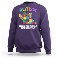 Purple crewneck sweatshirt with colorful autism graphic and 'Seeing the world differently' print