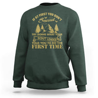 Forest green crewneck sweatshirt with long sleeves and front scout-style graphic print