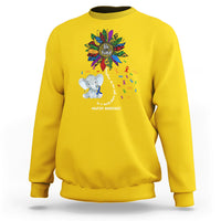 Yellow sweatshirt with Be Kind rainbow elephant puzzle awareness graphic