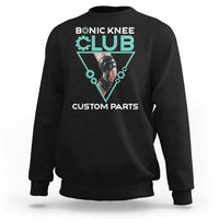 Black crewneck sweatshirt with robotic knee graphic print in teal triangle.