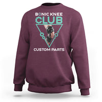 Maroon crewneck sweatshirt with robotic knee graphic print in teal triangle.