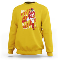 Yellow sweatshirt with "BELIEVE" text and football player graphic on front.