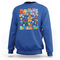 Blue crewneck sweatshirt with colorful “Be Different” graphic on chest