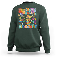 Forest green crewneck sweatshirt with colorful “Be Different” graphic on chest