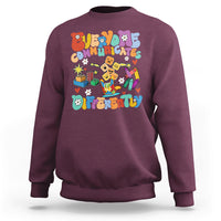Maroon crewneck sweatshirt with colorful “Be Different” graphic on chest