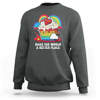 Dark gray sweatshirt with colorful rainbow baker graphic and “Bake the World” text