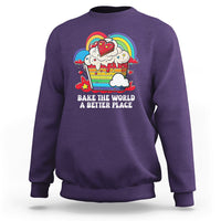 Purple sweatshirt with colorful rainbow baker graphic and “Bake the World” text