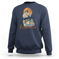 Navy women’s sweatshirt with front “Booktrovert” graphic of reader and stacked books