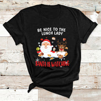 Black Christmas T-shirt with Santa and reindeer; text reads “Be Nice to the Lunch Lady”