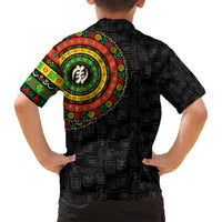 Kids black Hawaiian shirt back view with colorful circular emblem and repeating symbol pattern