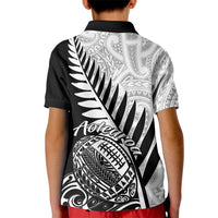 Kids black rugby polo shirt with white Aotearoa fern and tribal graphic on back
