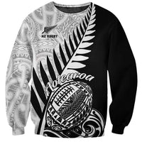 Black rugby sweatshirt with white Aotearoa text, fern leaf graphic, and football emblem
