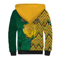 Sherpa hoodie back with yellow hood and green side panel, zigzag pattern and plant graphic