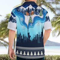 Blue holiday Hawaiian shirt from back with city skyline, snowflakes, and tree graphic; short sleeves.