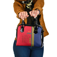 Two-tone Spain-themed handbag with red front panel, blue side panel, and black straps
