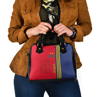 Two-tone red and blue shoulder handbag with black top handles and adjustable strap