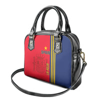 Red front and blue side structured handbag with black handles and crossbody strap