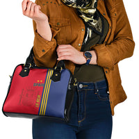 Red and blue shoulder handbag with black hardware, side straps, and branded crest