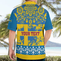 Back view of blue Hawaiian shirt with ornate yellow motifs and 'YOUR TEXT' stripe