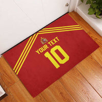 Red rubber doormat on wooden floor corner with yellow stripes, crest, custom text 10