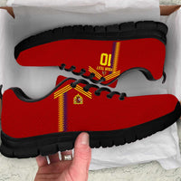 Red sneakers with yellow-red stripe and black outsole, white laces, textured upper
