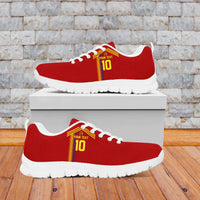 Red sneakers with yellow-red stripe, white laces, white tread outsole, on a box