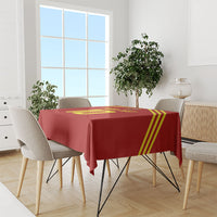 Red football-themed tablecloth with yellow stripes, draped on dining table with chairs
