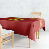 Red football-themed tablecloth with yellow stripes and emblem, draped over rectangular table