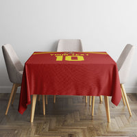 Red tablecloth with yellow number design centered, draped on dining table