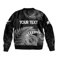 Black bomber jacket with ribbed hem and large white fern spiral graphic on back