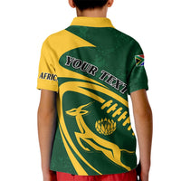 Kids green and yellow polo shirt, back graphic with text and antelope motif, flag sleeve