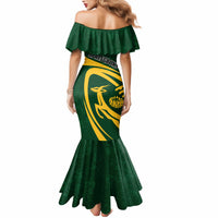Green off-shoulder mermaid dress, back view, yellow shield emblem and ruffled hem