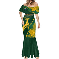 Women’s green fitted mermaid dress with gold sunflower-style print and off-shoulder neckline