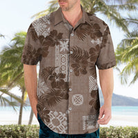 Brown Hawaiian shirt with white floral print and button placket, short sleeves.