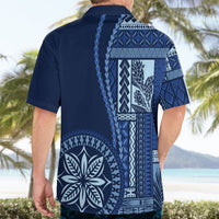 Blue short-sleeve Hawaiian shirt with back siapo patterns and leaf emblem.