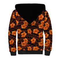 Sherpa-lined hoodie with black hood, orange hibiscus flowers, tribal pattern on back