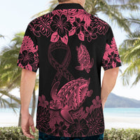 Back view of pink and black Hawaiian shirt with turtle, hibiscus-style flowers, and ribbon