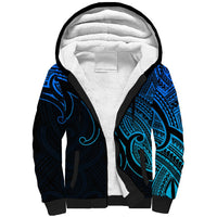 Sherpa hoodie with blue-and-black Maori-inspired pattern, white fleece-lined hood
