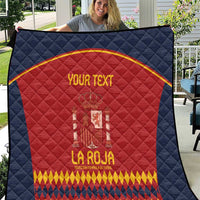 Blue quilt with red Spain crest and gold text, diamond quilted pattern