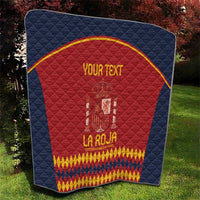 Square blue quilt featuring red center with Spain crest and yellow-gold text