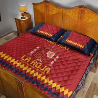 Red quilt bed set with navy and yellow patterned pillows on a wooden bed frame