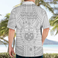 White Hawaiian shirt back with gray tribal crest and Manuia-style lettering.