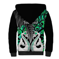 Sherpa hoodie with large green tribal print and white feathered motifs on back