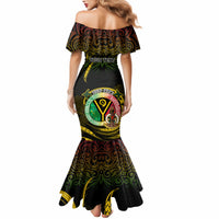 Black off-shoulder fitted dress with green and yellow festive emblem print