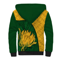 Sherpa hoodie back with green body, yellow kente-style panel, large protea graphic