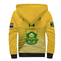 Yellow sherpa hoodie with hood, green emblem and horizontal stripe graphic on back