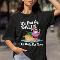 Black Christmas in July graphic T-shirt worn by model, showing Santa on float and palm trees